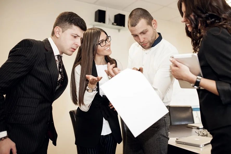 A legal team analyzing documents and discussing important factors in selecting a class action attorney.