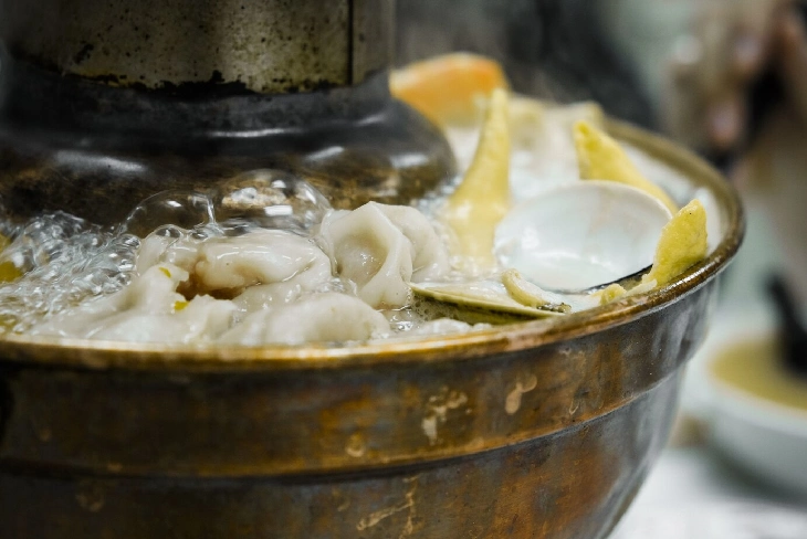 A vibrant scene of a steaming pot filled with fresh ingredients, capturing the irresistible essence of Steamboat dining. Steamboat!