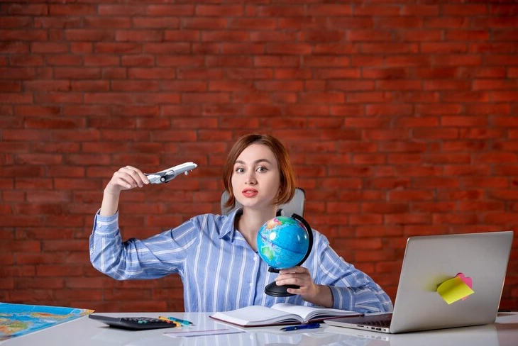 Globe with currency symbols and laptop for management international payroll.