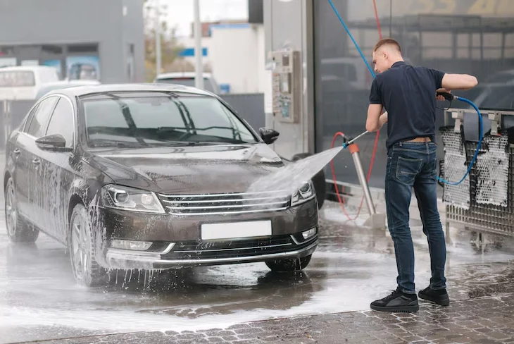 Mobile car wash service cleaning a car at home.