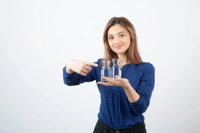 Individual holding a glass of water, considering the implications of a 2-day water-only diet for weight loss.​