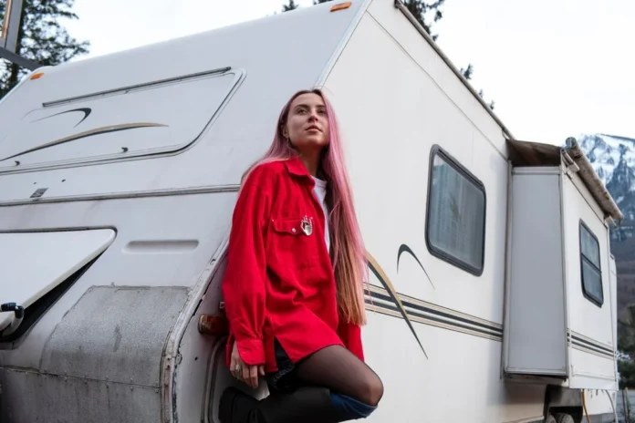 Young woman sitting on her RV thinking about buying an RV extended warranty for travel protection.