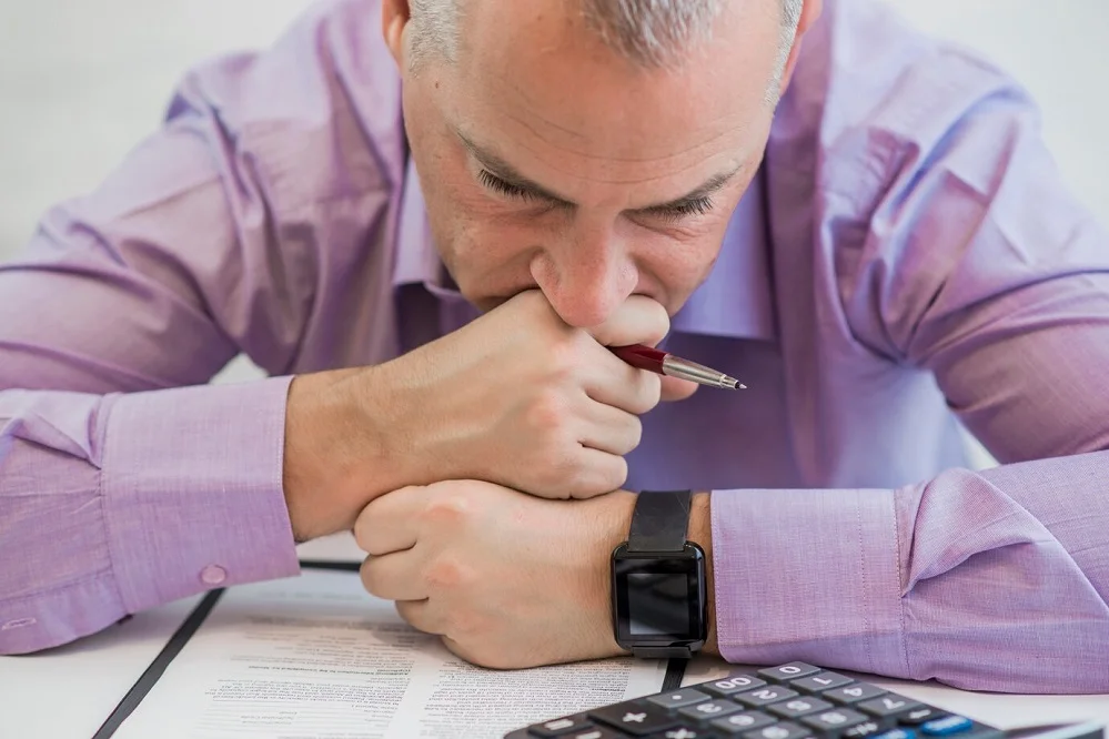 A worried man reviewing legal documents, representing the stress of facing DUI charges and the legal steps involved.