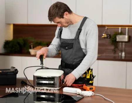 Technician performing appliance repair on a refrigerator, demonstrating essential home maintenance skills