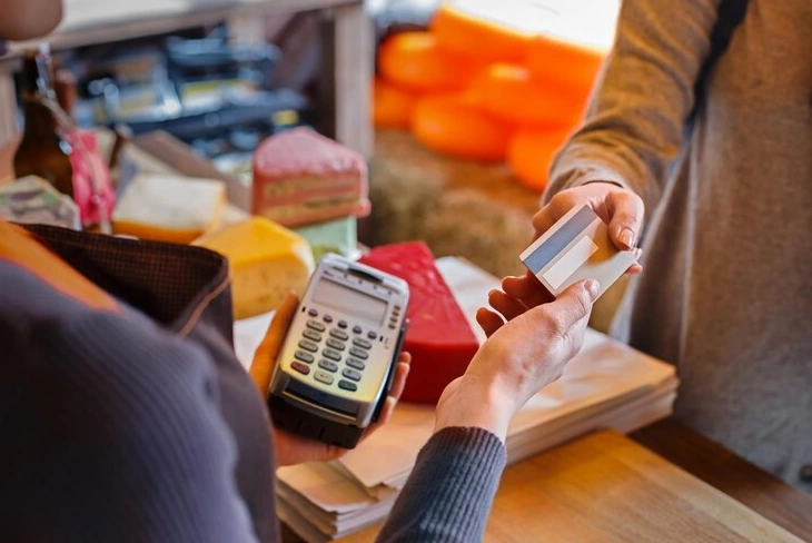 Customer using EFTPOS machine for payment at a store.