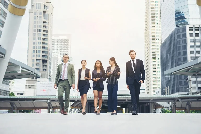 Business professionals from Consortium Enterprises Navoou walking together in a modern urban setting.