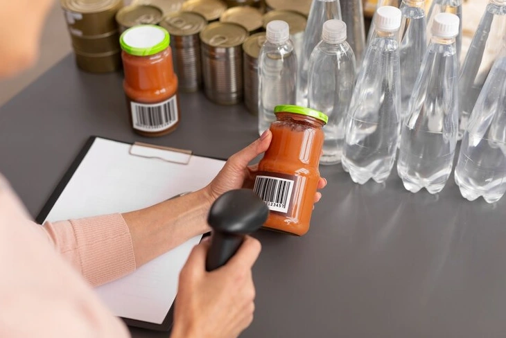 Labeling machines applying labels to bottles on a conveyor belt.