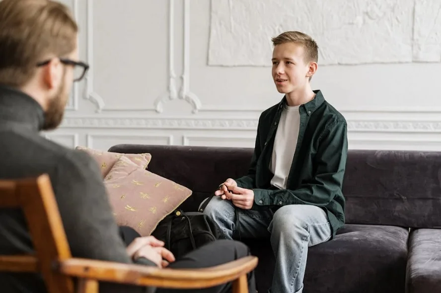 A young person talking to a therapist during a mental health session.