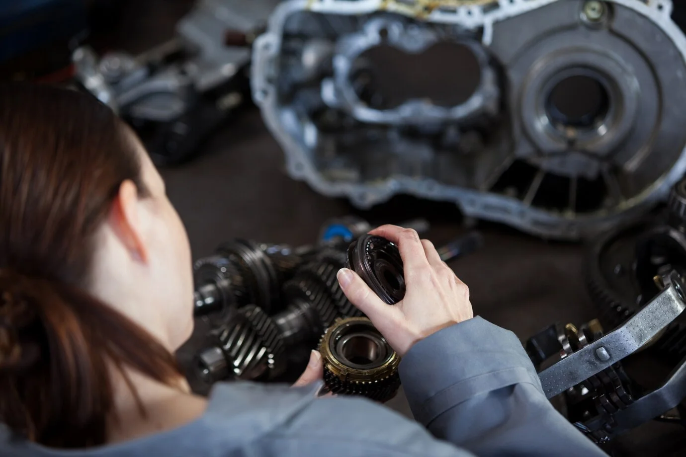 Mechanic handling diesel engine parts with precision, highlighting the need for genuine components to ensure engine efficiency.