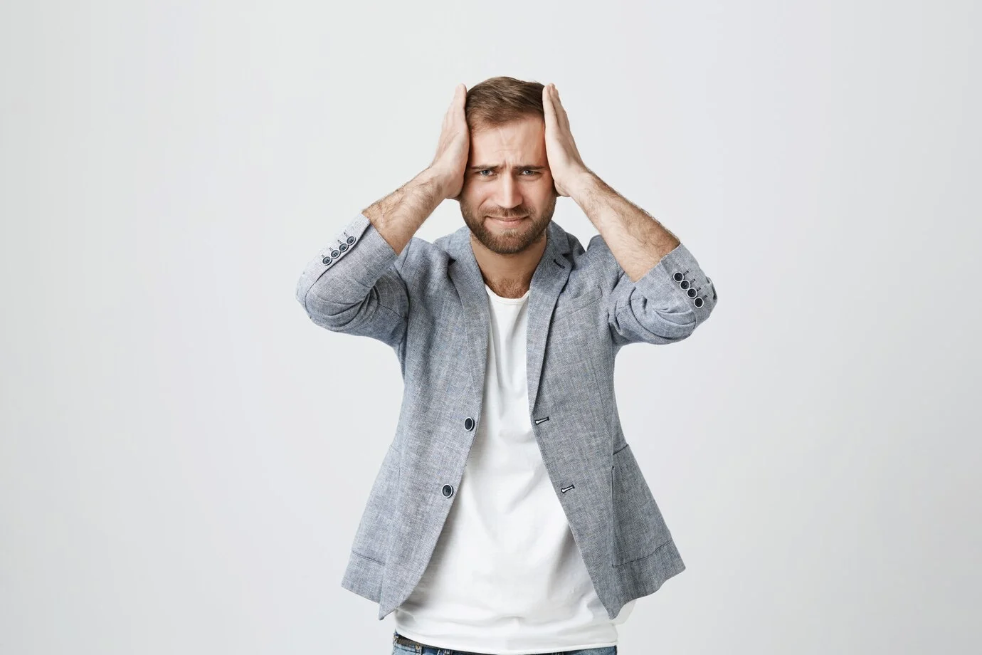 A man holding his head in distress, illustrating the impact of stress on emotional and mental health during recovery.