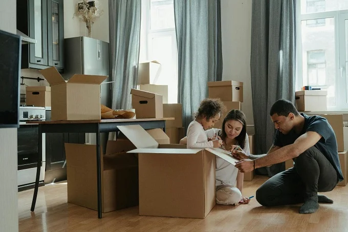 Family unpacking boxes in a new home after moving.
