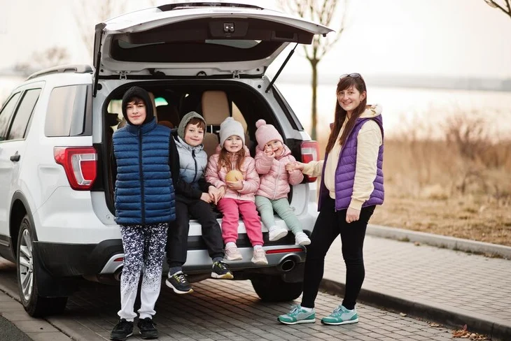 Spacious SUV best vehicle for family of five, parked in scenic driveway.