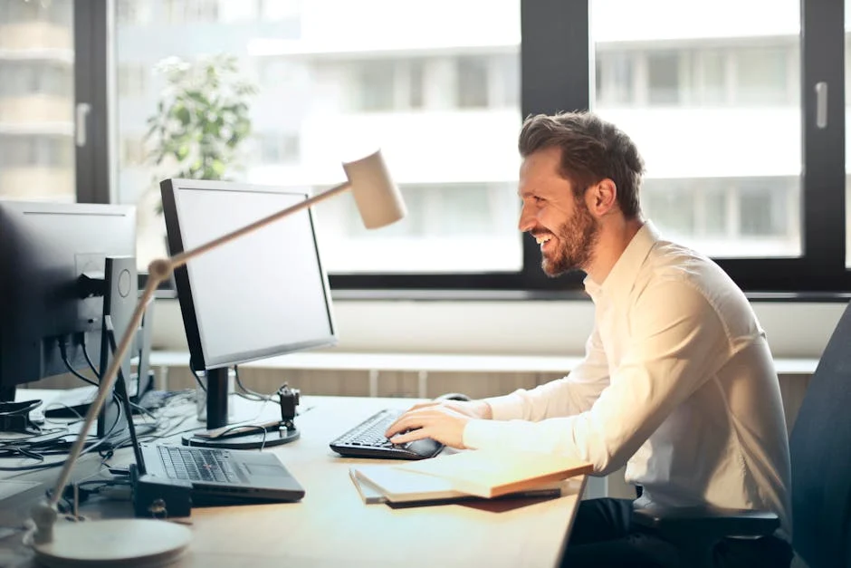 A business professional smiling at his desk while working on corporate law compliance strategies.