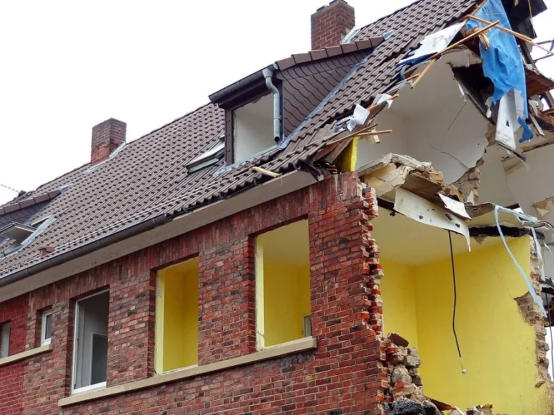 A damaged house wall, showing the importance of selecting moisture-resistant insulation for long-term protection.